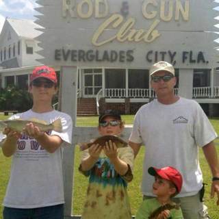 	Father and 3 boys in front of Rod & Gun Club