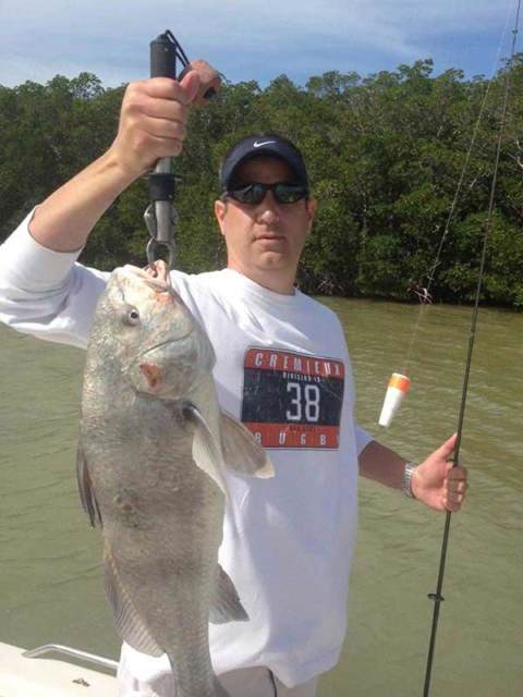 A customer holding up a fish he caught on the charter