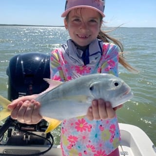 A young girl holds up her catch