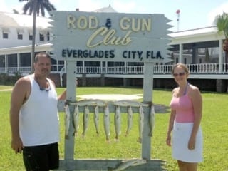 	Husband and wife showing off their catch in front of Rod & Gun Club