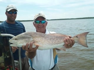 Father and son and a gigantic fish caught on a charter